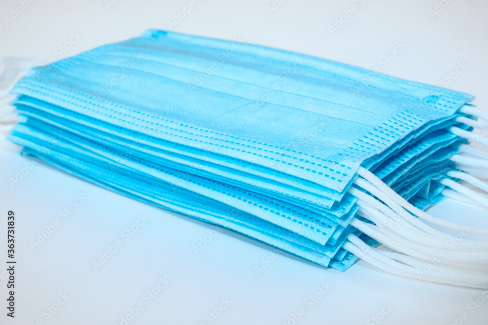 Close up of isolated pile of stacked light blue ear loop mask Close up of isolated pile of stacked light blue ear loop mask
