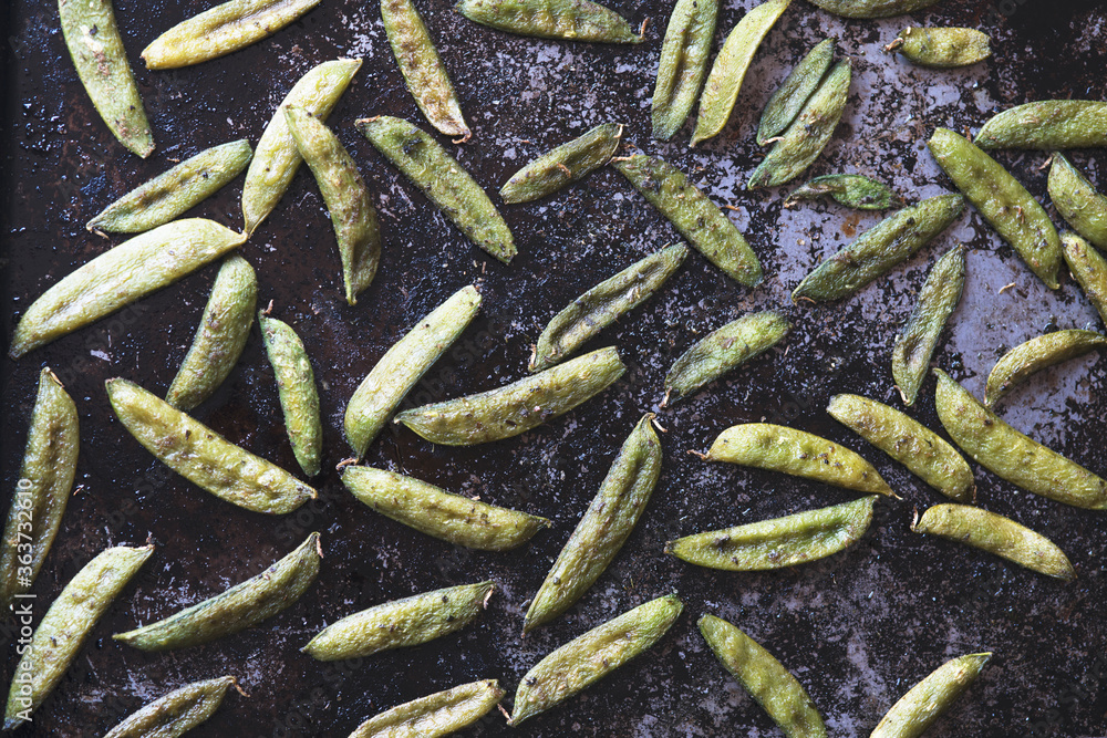 Roasted snow peas on black pan in natural light Roasted snow peas on black pan in natural light