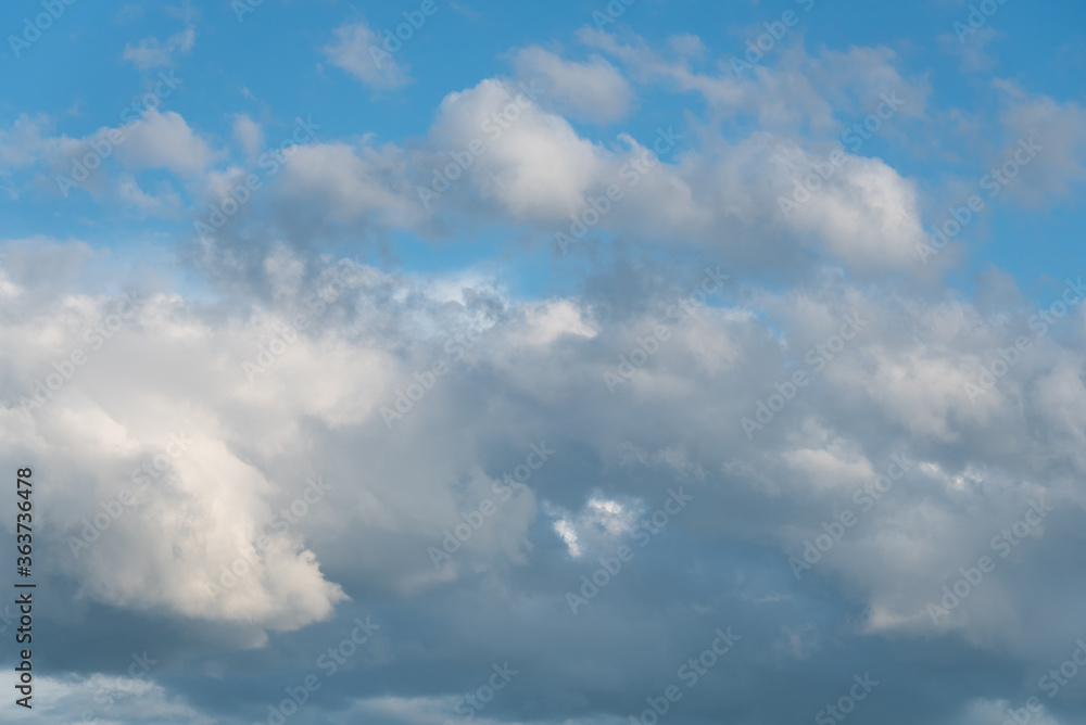 Atmospheric blue sky with gray and white clouds
