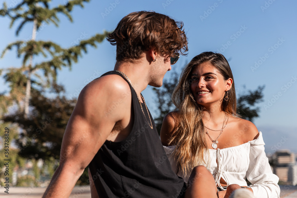 young caucasian couple in love sitting playing young caucasian couple in love sitting playing