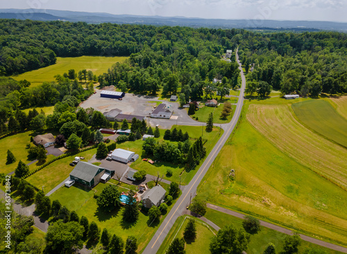 Aerial view from the height of the village with houses streets fields, meadows in the summer