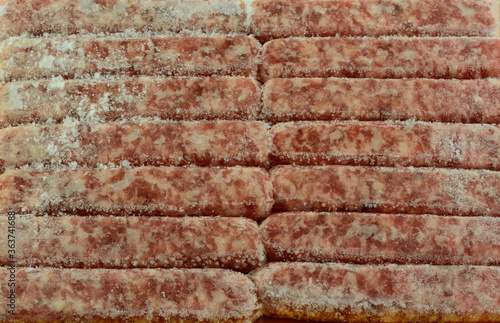 Fotografija Closeup of frozen sausage meat links with ice crystals thawing