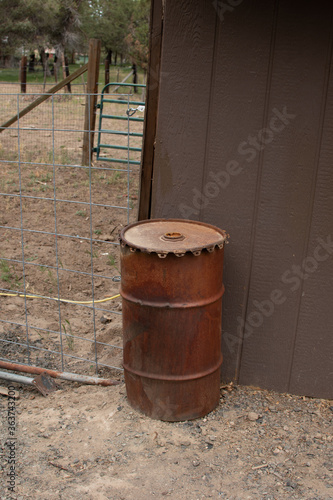 Old rusted barrel full of creosote and oil mixture commonly used by ranchers and farmers to preserve wood. Now needs safely disposed of.