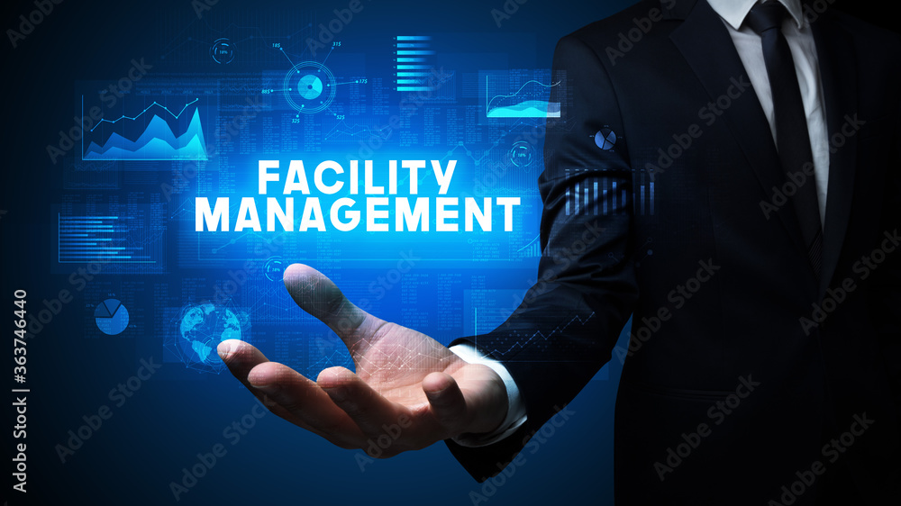 Hand of Businessman holding FACILITY MANAGEMENT inscription, business success concept Hand of Businessman holding FACILITY MANAGEMENT inscription, business success concept