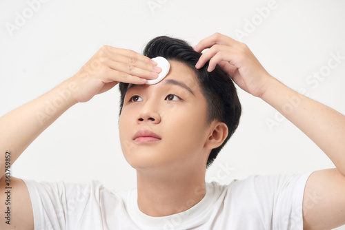 Wallpaper Mural Beauty portrait of a handsome man standing isolated over white background, using cotton pad Torontodigital.ca
