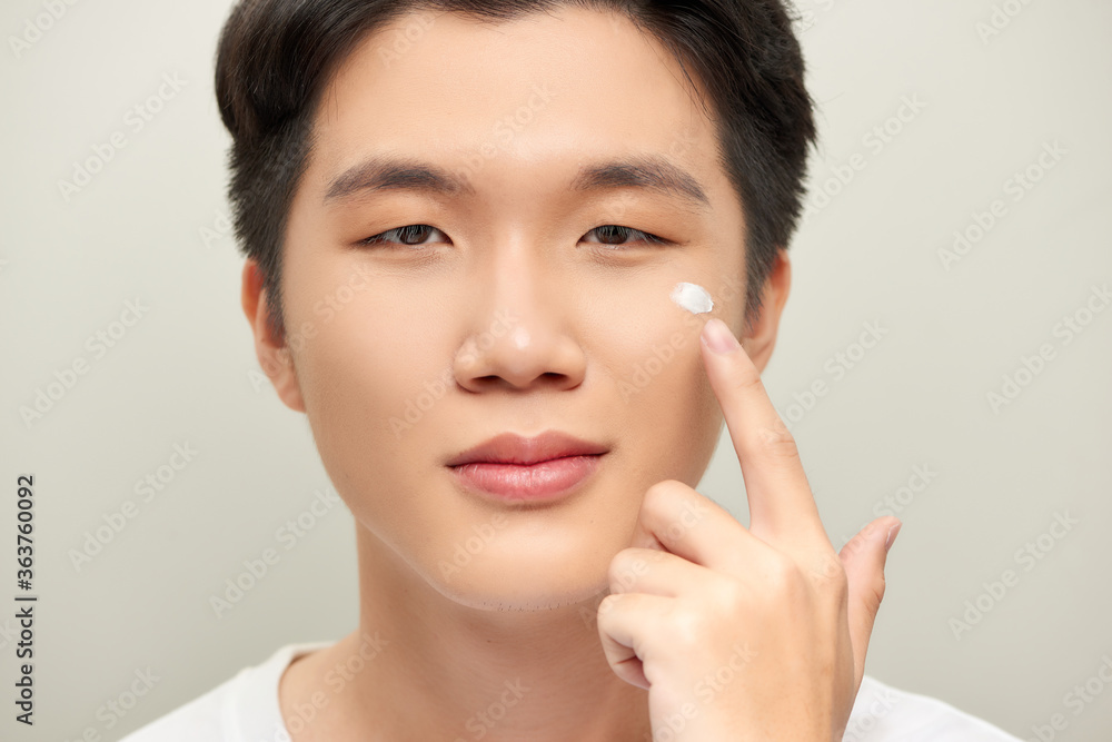 Young man with moisturizer on the face Young man with moisturizer on the face