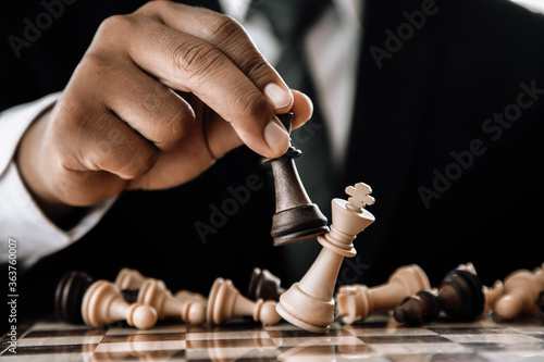 Hand of businessman moving chess figure in competition success play. strategy, toned retro effect.