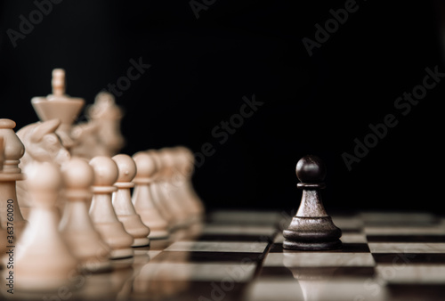 Set chess on a chessboard background. The central figure-pawn is on focused. Teamwork concept.
