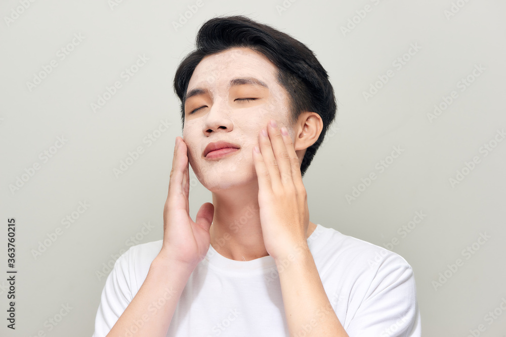 Handsome man with clay mask on his face against white background Handsome man with clay mask on his face against white background