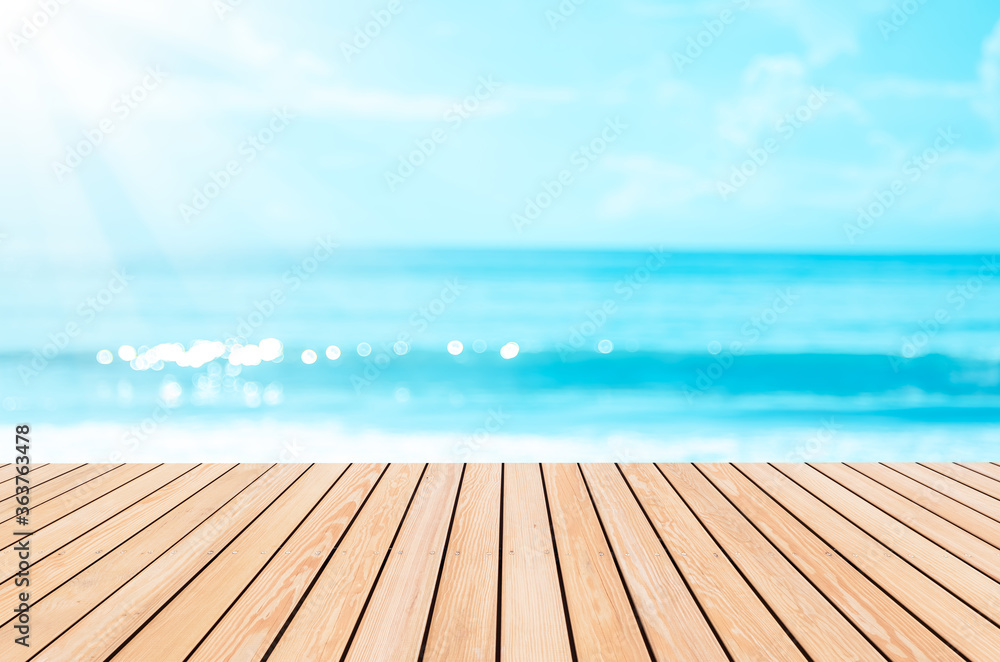 Blur tropical beach with bokeh sun light wave on empty old nature wood table abstract background. Blur tropical beach with bokeh sun light wave on empty old nature wood table abstract background.