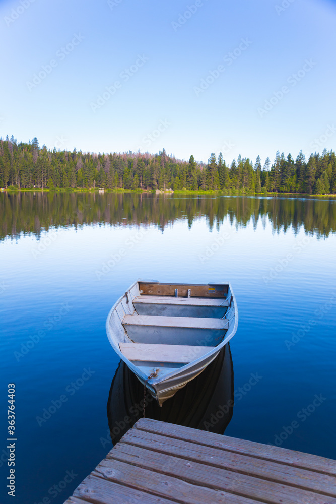 A close-up rowboat with reflection floating on Sequoia Lake, vacation