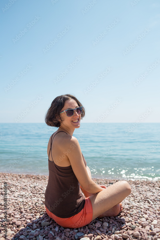 Smiling girl looks at the sea.