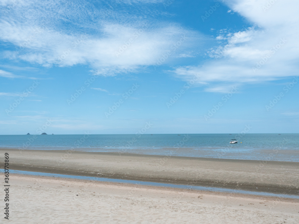 Beach with sea smooth and white cloud on beautiful blue sky , Fluffy clouds formations at tropical zone , Holiday activities on the sand at Pranburi Beach , Thailand