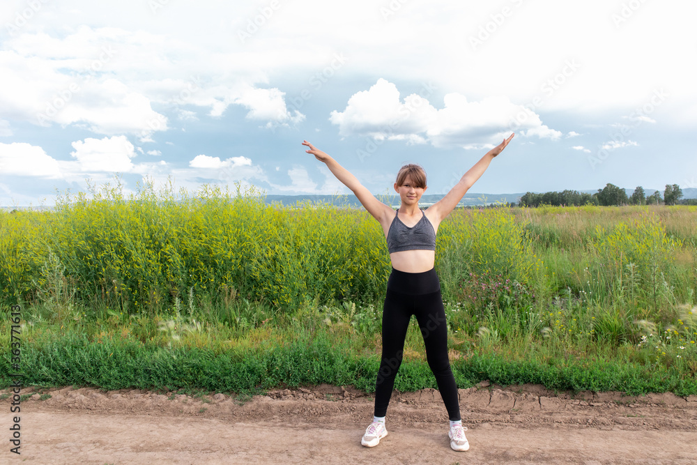 Fitness sport child girl in sportswear doing stretching exercise outdoors. Workout in the park Fitness sport child girl in sportswear doing stretching exercise outdoors. Workout in the park