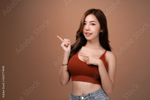 Slim body and big breast asian woman present a special promotion, Red crop bralette outfit, isolated with mocha brown background