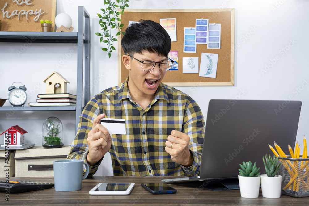 Asian man holding credit card to Online shopping with laptop computer and entering security code
Asian man holding credit card to Online shopping with laptop computer and entering security code