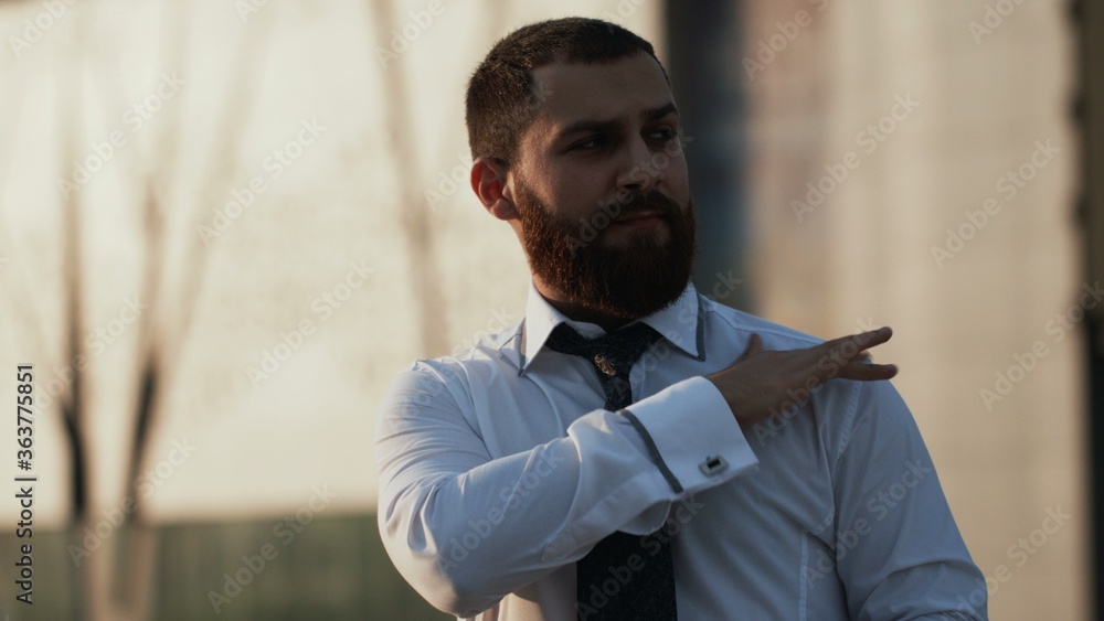 Handsome Businessman straightens his clothes while waits for somebody Handsome Businessman straightens his clothes while waits for somebody