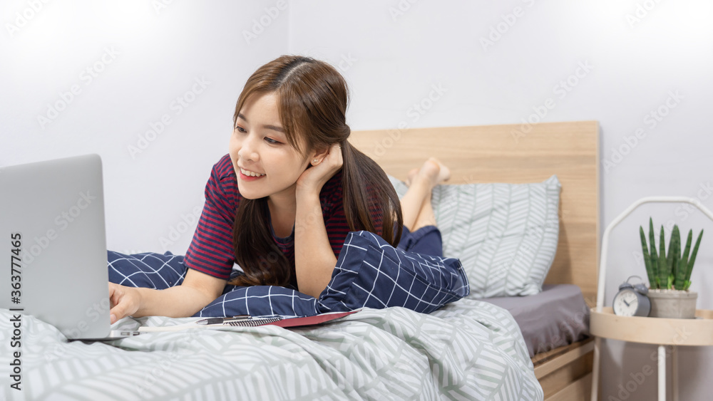 Asian woman working with smartphone or laptop in bedroom at her home
Asian woman working with smartphone or laptop in bedroom at her home