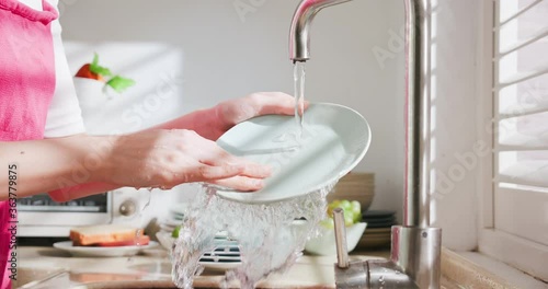 Asian housewife wash dishes