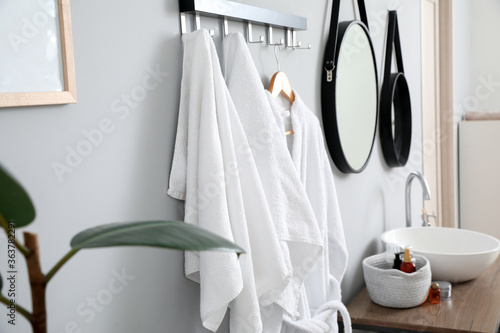 Hanger with clean towels in bathroom © Pixel-Shot