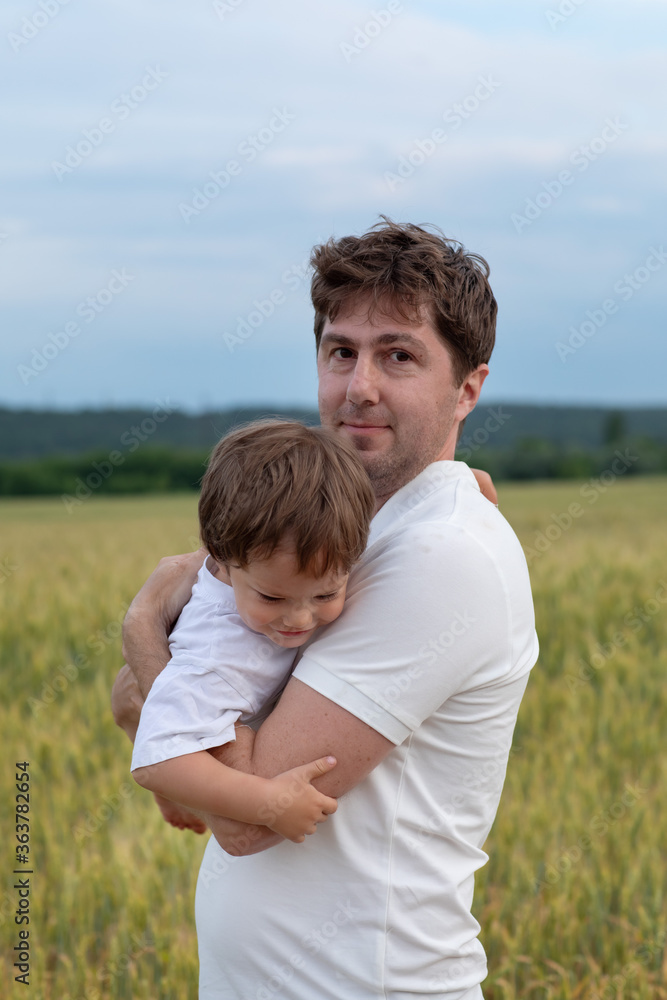 Father and little son walking in the field Father and little son walking in the field