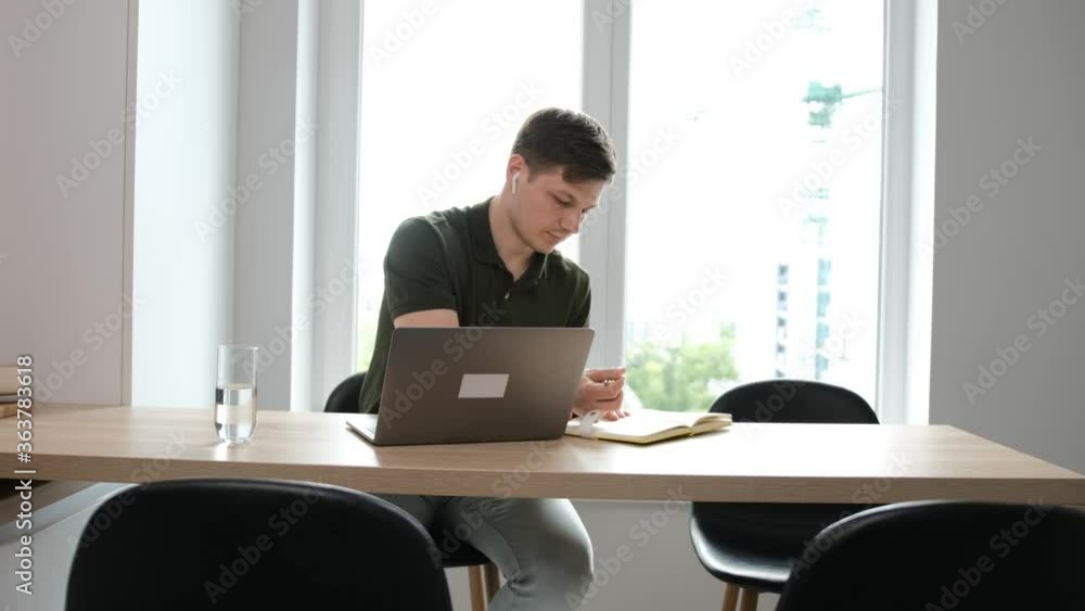 Businessman work at the laptop and making some important notice in the notebook. Work from home due the pandemic situation. Businessman work at the laptop and making some important notice in the notebook. Work from home due the pandemic situation.