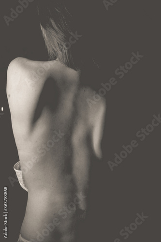 a black-and-white photo of a girl with a naked back.