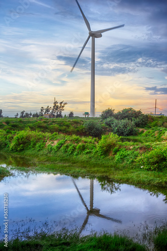 The wind turbine in the evening is reflected in the water. © 一飞 黄