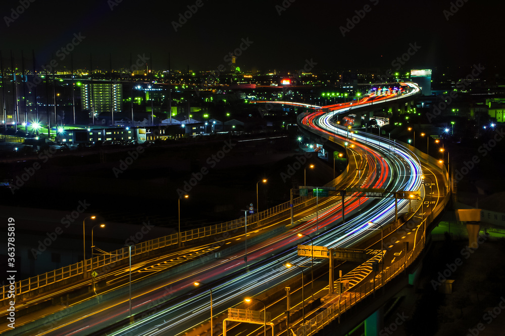 高速道路を走る車のヘッドライトの河