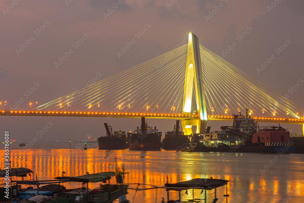 Obraz premium A bridge crosses the sea at night in hainan, China.