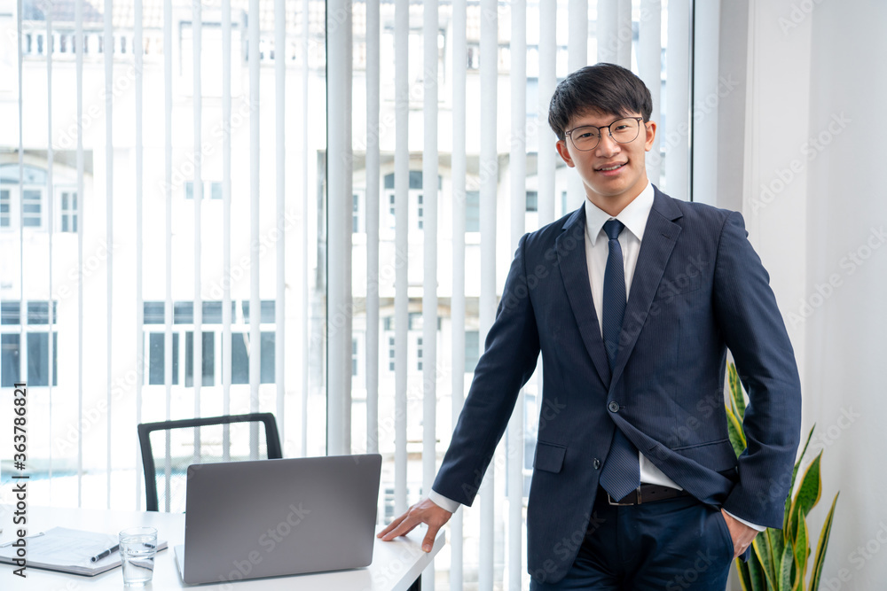 Attractive handsome Asian businessmen in glasses smiling positive happy and cheerful in his office workplace looking at the camera. Attractive handsome Asian businessmen in glasses smiling positive happy and cheerful in his office workplace looking at the camera.