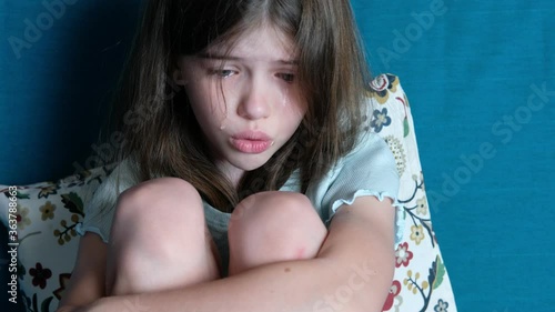 little girl swears with parents, protests, cries, tears on her cheeks