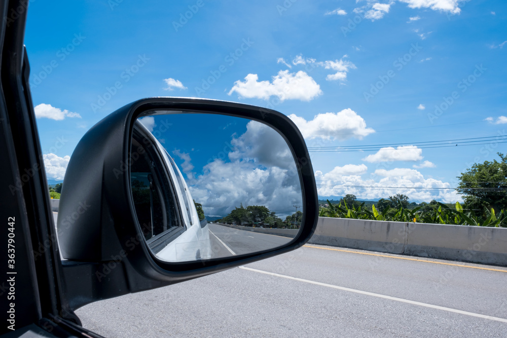 Beautiful clouds and sky landscape from the window of the car on road, reflection on the side mirror in travel the countryside