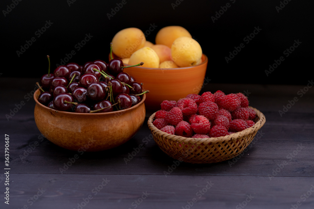 Cherry, raspberries and apricots on a wooden background Cherry, raspberries and apricots on a wooden background