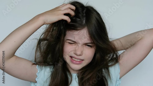 the little girl has lice, she scratches her head and it bothers her