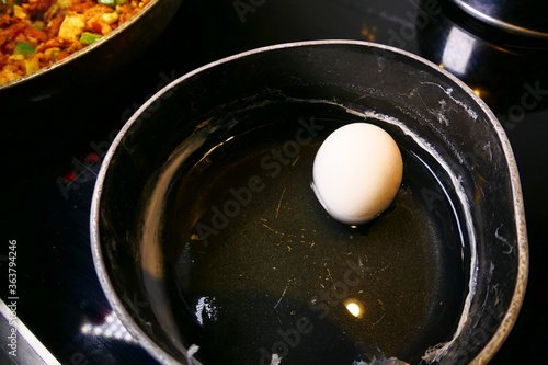 A hard-boiled egg in a pot with water
