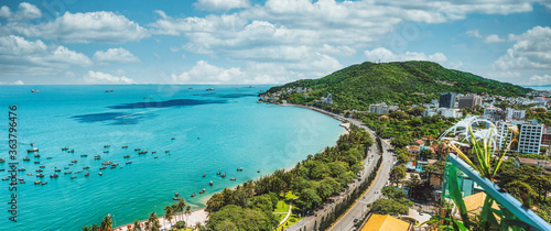 Panoramic coastal Vung Tau view from above, with waves, coastline, streets, coconut trees and Tao Phung mountain