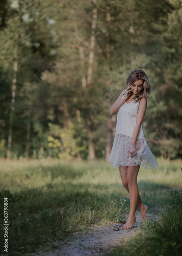 girl in a white dress walks through the woods © Наталья Бирюкова