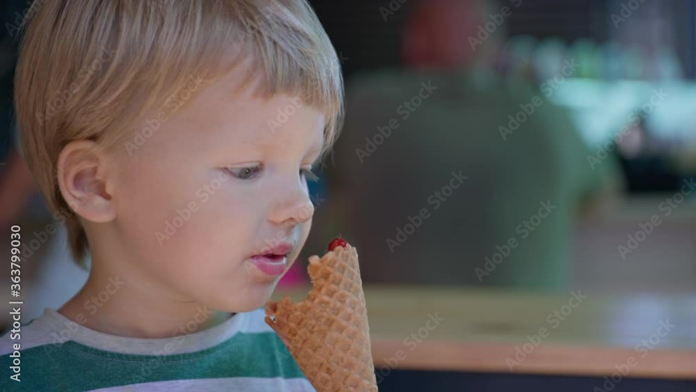 ice cream, little attractive boy enjoys licking his tongue in the summer cool dessert popsicles in waffle cup during summer vacation ice cream, little attractive boy enjoys licking his tongue in the summer cool dessert popsicles in waffle cup during summer vacation