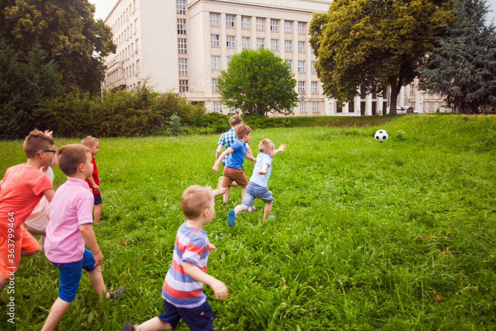 Obraz premium Elementary school kids play football after school