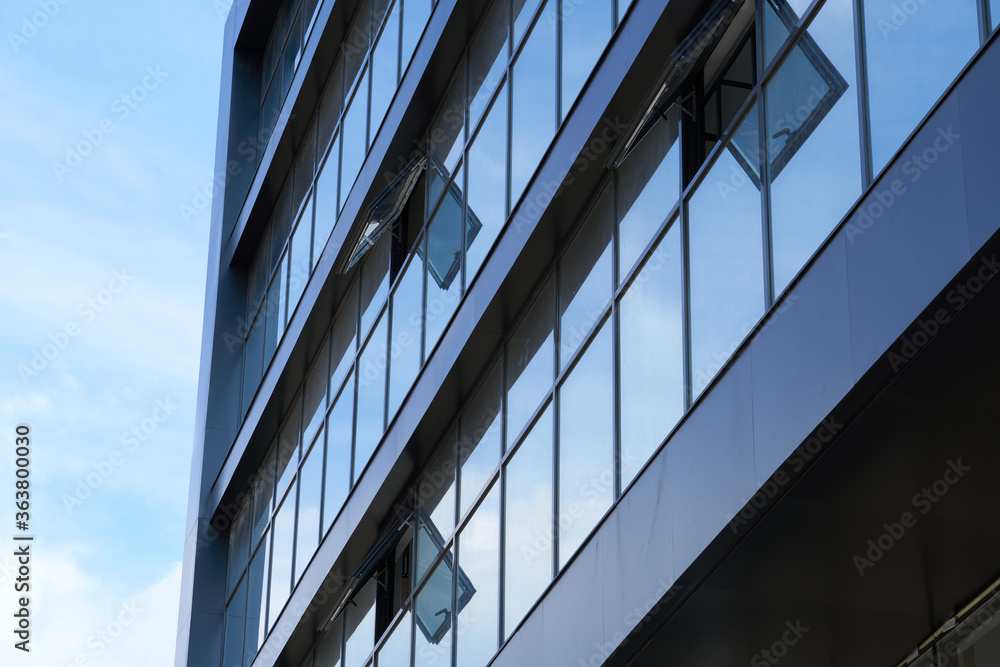facade of a modern building on a bright Sunny day, blue sky and clouds reflecting in a glass, beautiful exterior of the new building facade of a modern building on a bright Sunny day, blue sky and clouds reflecting in a glass, beautiful exterior of the new building