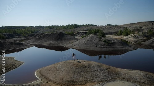 Incredible view of the Ural careers in Bogdanovich. Exercise outdoors next to the lake. The girl conducts a training in nature.  photo