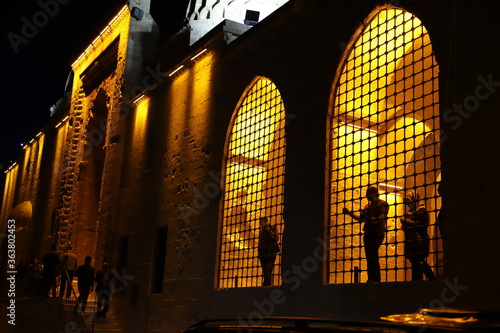 Mardin Artuklu ilçesinde bulunan tarihi Kasımiye Medresesinde ışık, insan ve yansıma photo