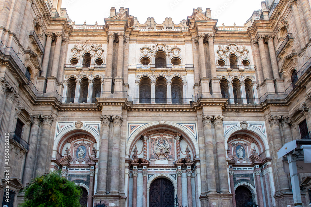 The Cathedral of Malaga front symmetrical view. Medieval Roman Catholic church in renaissance style with baroque facade with arches and portals. Malaga, Andalusia, Spain. 