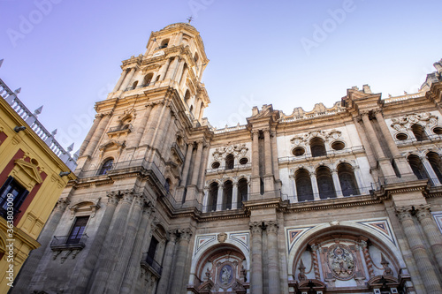 The Cathedral of Malaga front view from below with lavender sky in the background. Medieval Roman Catholic church in renaissance style with baroque facade with arches and portals. Malaga, Spain. © Cleop6atra