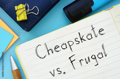 Cheapskate Vs. Frugal sign on the piece of paper. photo