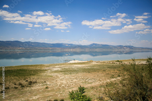 Reflection of the mountains in Burdur Lake. Wooden pier on the lake.