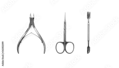 Manicure and pedicure nail care tools set isolated on white background, top view. Cuticle pusher, cuticle trimmer and purpose scissor