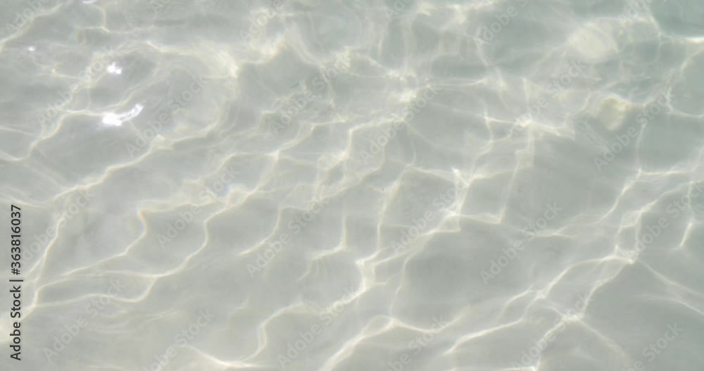 Water surface texture on sand, Slow motion clean white sands ripples and wave, Refraction of sunlight top view texture sea side white sand, sun shine water loop background. Water surface texture on sand, Slow motion clean white sands ripples and wave, Refraction of sunlight top view texture sea side white sand, sun shine water loop background.