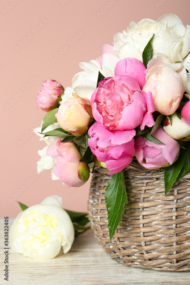 Basket with beautiful peonies on wooden table Basket with beautiful peonies on wooden table